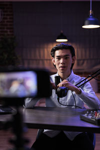 Portrait of young man sitting on table