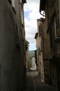 Narrow alley amidst old buildings against sky