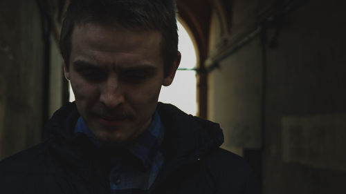 Close-up of young man looking down at home