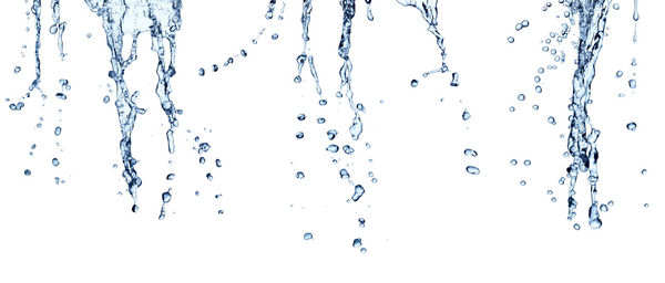 Close-up of water drops on glass against white background