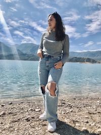 Portrait of young woman standing at beach