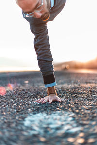 Man doing handstand on road during sunset