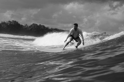 Man surfing on sea against sky