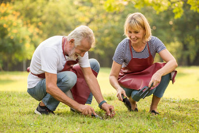 Man and woman gardening with tools in park