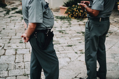 Low section of security guard standing outdoors