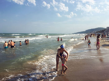 People at beach against sky