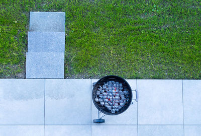 High angle view of stone floor and smoldering grill