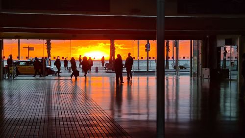 Silhouette people walking in city during sunset