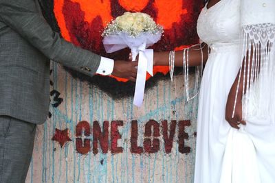 Close-up of woman with text on wall