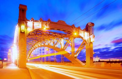 Night saint petersburg bridge named after pefer the great with ling light trails under dramatic sky