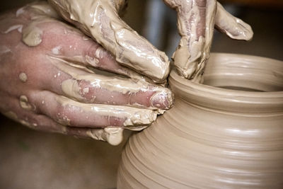 Hands in the clay macro. making crock crude wet close-up. man hands making clay jug macro. 