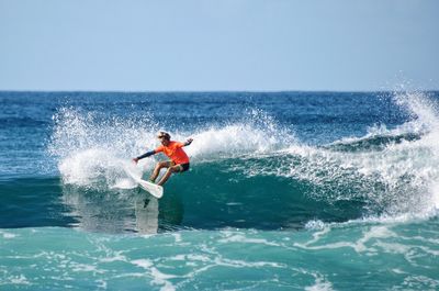 Man surfing on sea against clear sky