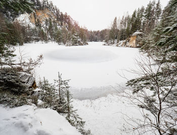 Frozen blue lake in adrspach natural park. winter hiking in popular in rocky labyrinth in czechia