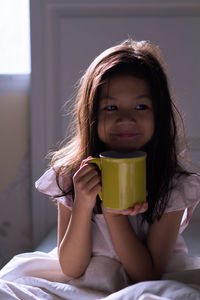 Portrait of girl lying on bed at home