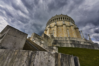 Low angle view of old building against cloudy sky