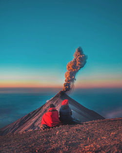 Rear view of people sitting on landscape