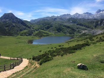 Scenic view of green landscape and mountains against sky