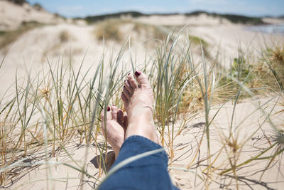 Low section of woman relaxing at beach