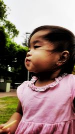 Close-up of cute baby girl looking away