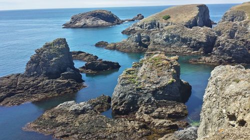 Panoramic view of rocks on sea shore against sky