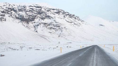 Snow covered landscape with mountain range in background