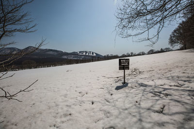 Snow covered land and mountains against sky