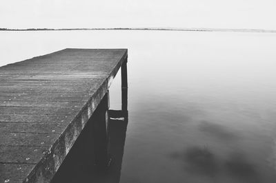 Wooden pier on sea against sky