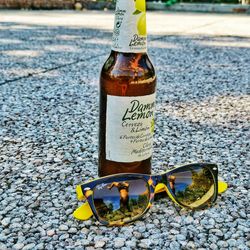 Close-up of sunglasses with text on road