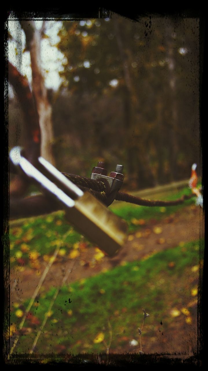 transfer print, auto post production filter, focus on foreground, close-up, selective focus, metal, grass, outdoors, day, wood - material, fence, no people, part of, field, sunlight, protection, nature, safety, metallic, rusty