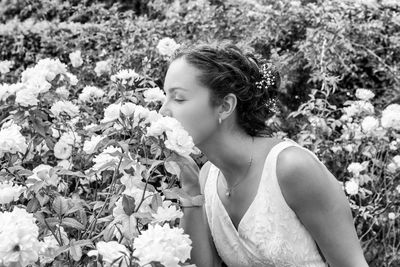 Bride smelling roses at park