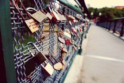 Padlocks hanging on railing by footbridge