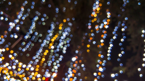 Low angle view of illuminated lights against sky at night