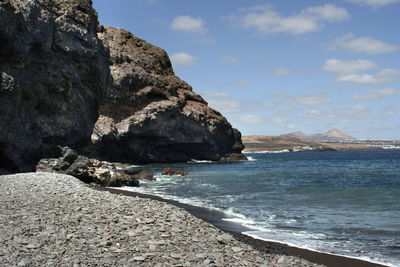 Scenic view of sea and mountains against sky