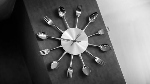 High angle view of spoons and forks forming wall clock