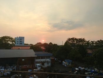 High angle view of trees and buildings against sky during sunset