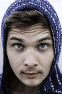 Close-up portrait of man wearing hooded shirt