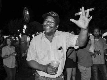 Portrait of man with arms raised at music concert