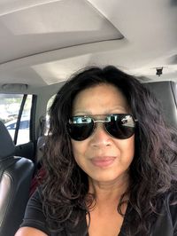 Portrait of young woman wearing sunglasses while sitting in car