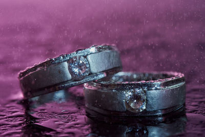 Close-up of wedding rings on table during rainfall