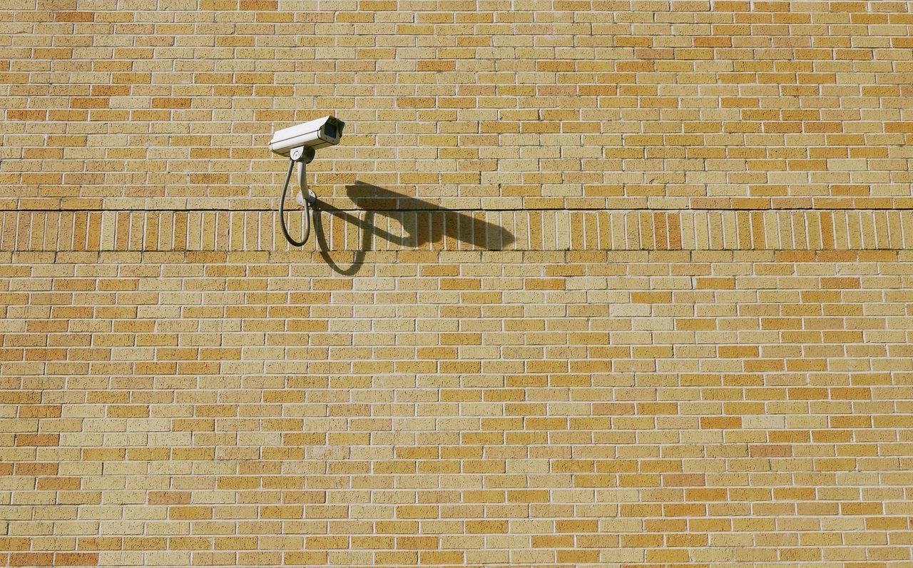 wall - building feature, tile, architecture, built structure, wall, brick, flooring, pattern, brick wall, no people, day, shadow, security camera, surveillance, outdoors, sunlight, building exterior, electricity, tiled floor, nature