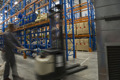 Warehouseman in storehouse working with pallet jack