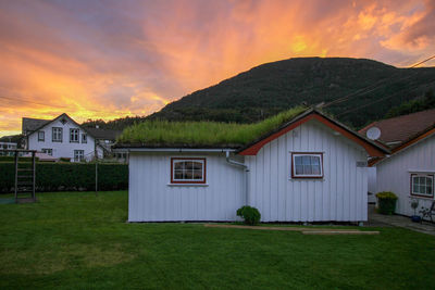 House on field against sky during sunset