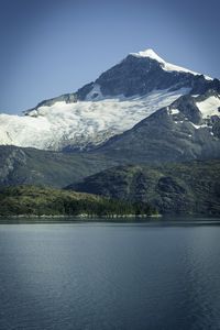 Scenic view of lake by snowcapped mountains against sky