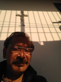 Portrait of young man wearing sunglasses against wall