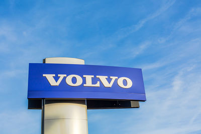 Low angle view of road sign against blue sky