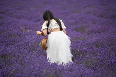 Rear view of woman with arms raised on field