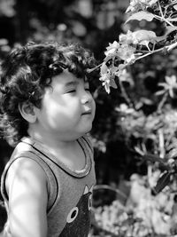 Cute boy standing by flowering plants