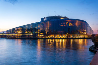 Illuminated buildings in city at waterfront