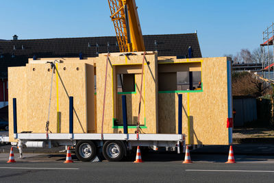 Ready for unloading panels of a wooden prefabricated house. crane boom at the back. car trailer.