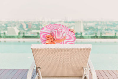 Rear view of hat on chair against sea